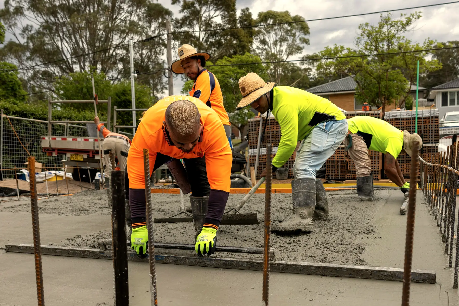 A concrete finisher trowels a fresh driveway slab.